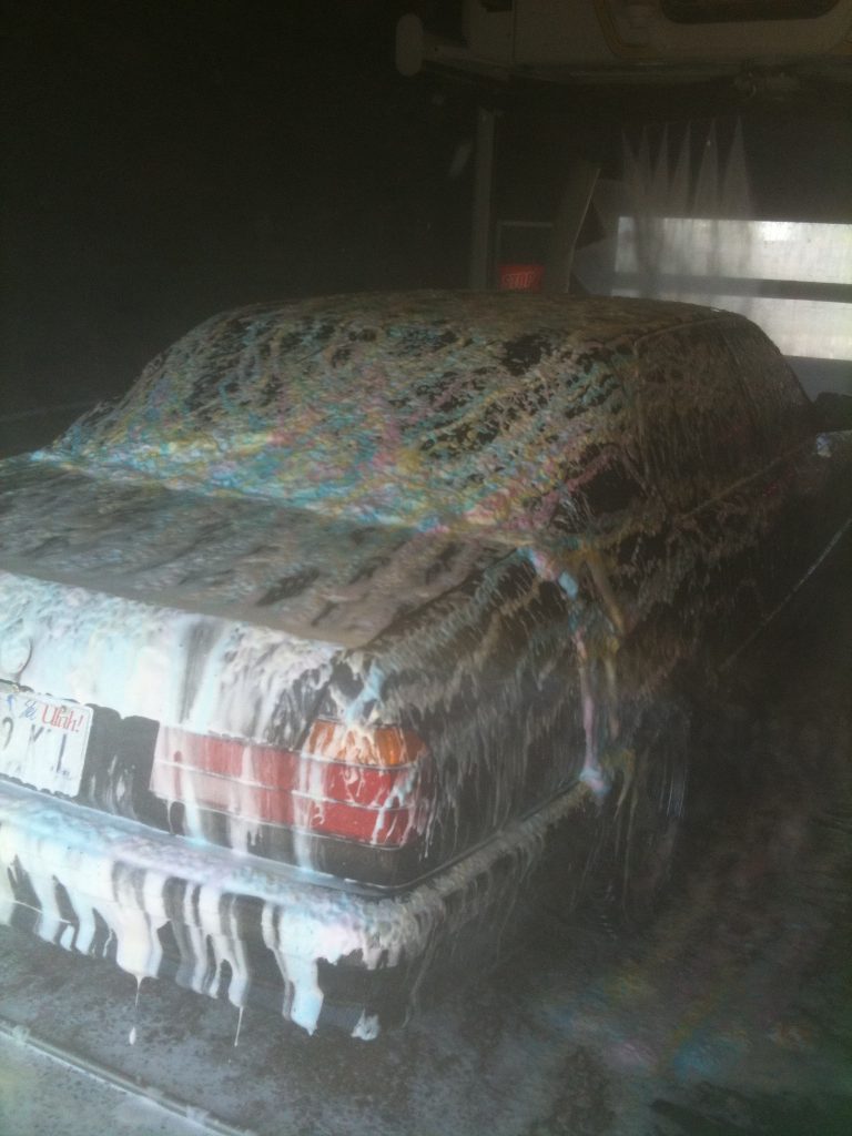 Car with soap on it inside car wash